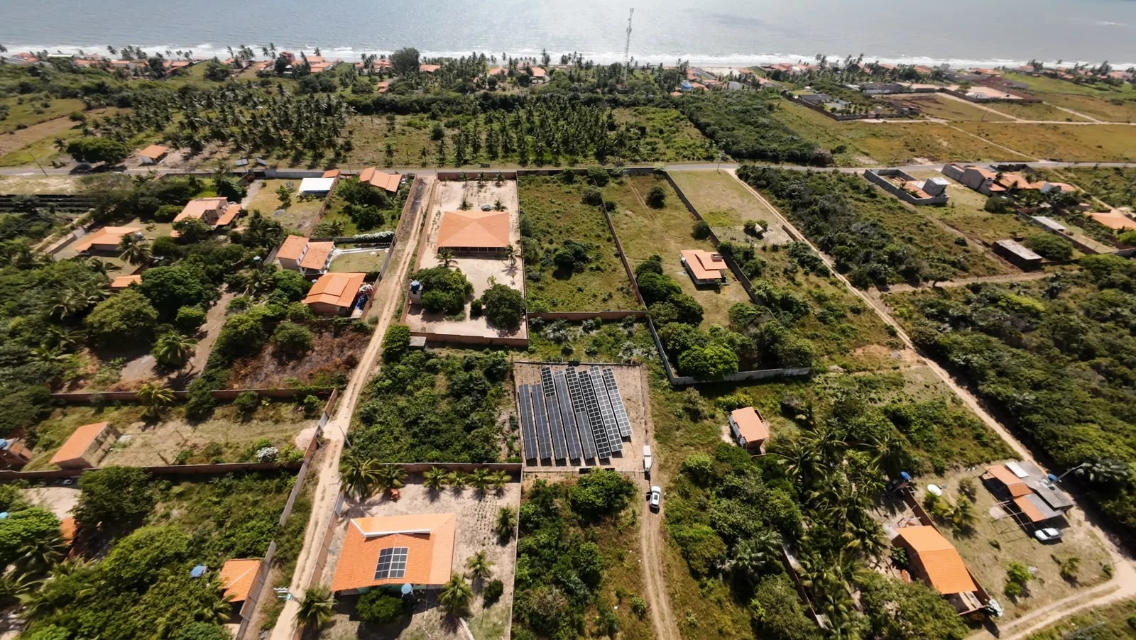 Vista aérea panorâmica de uma usina solar próxima ao litoral.